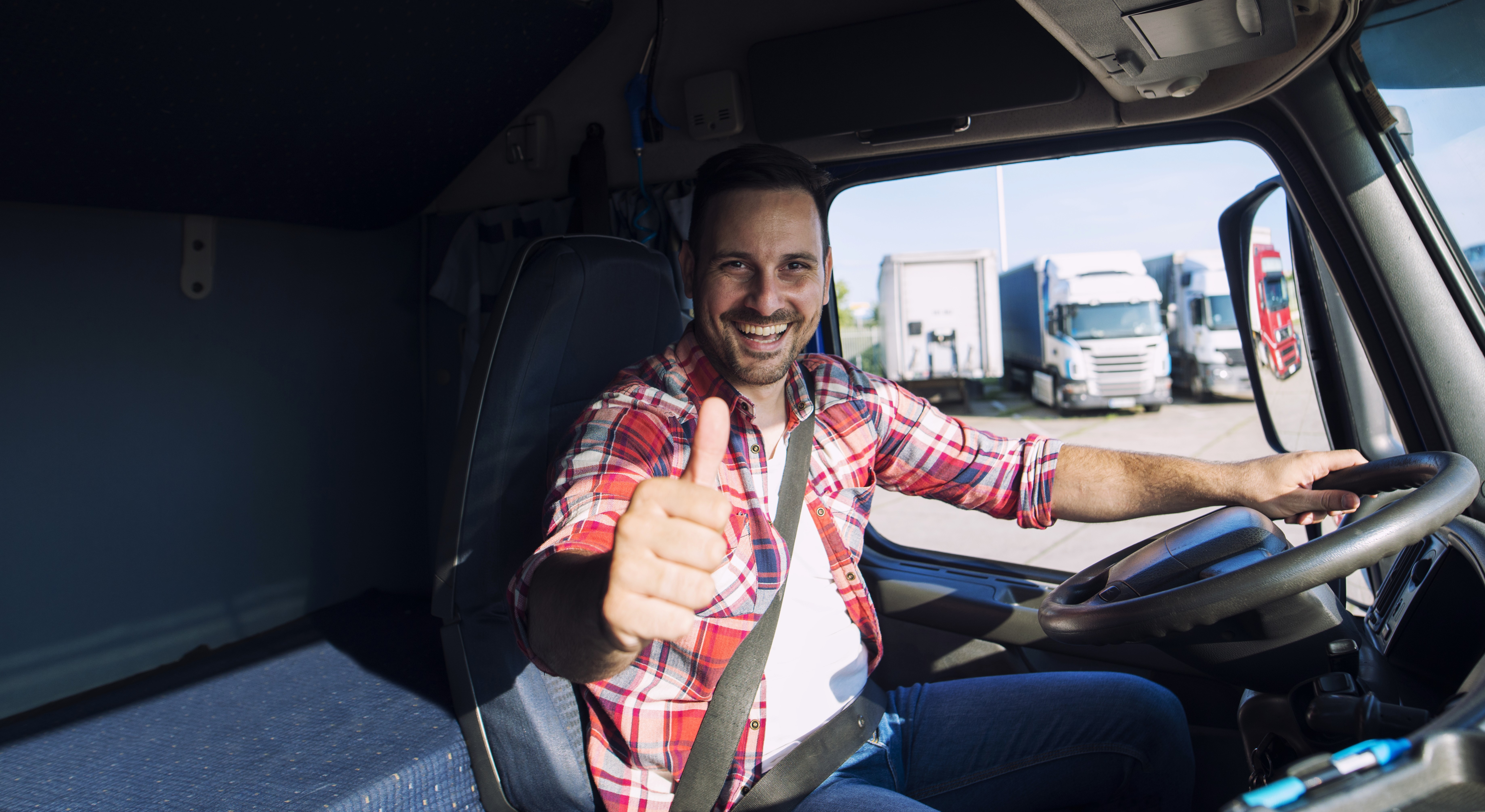 retrato-de-conductor-de-camion-motivado-profesional-sosteniendo-thumbs-up-en-la-cabina-del-camion