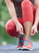 Mujer amarrándose los zapatos 